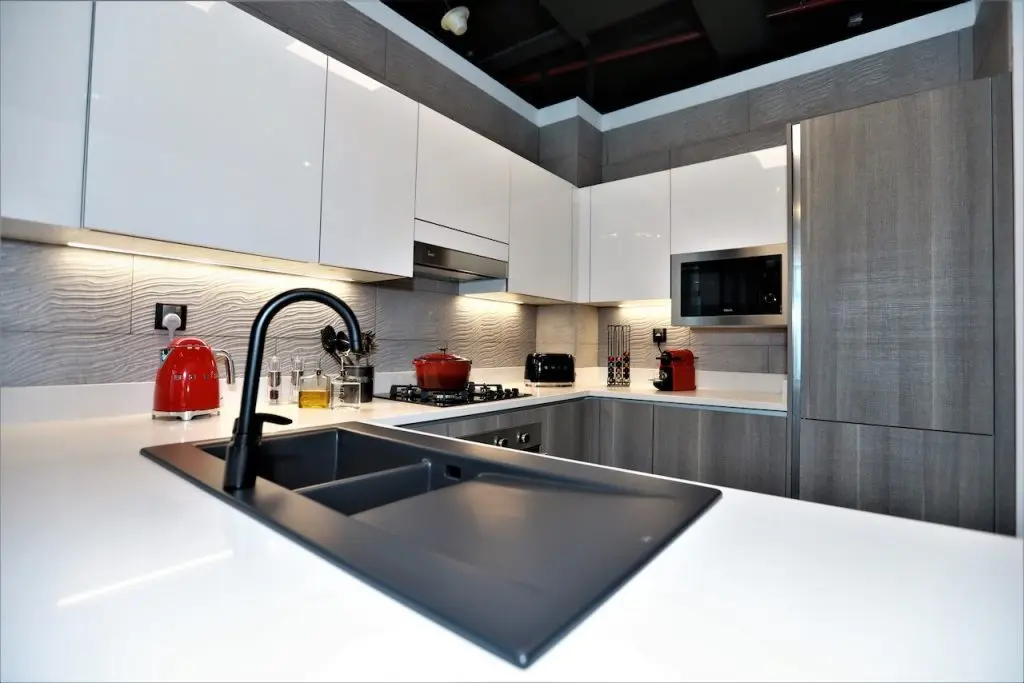 Kitchen with white worktop and black sink