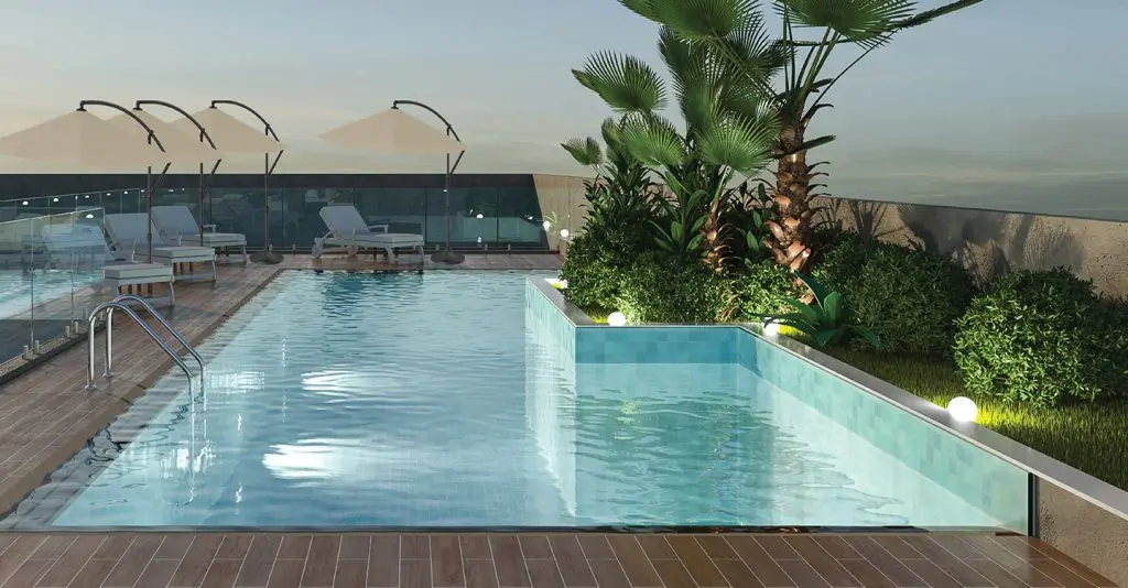 Rooftop pool with loungers, umbrellas and palms