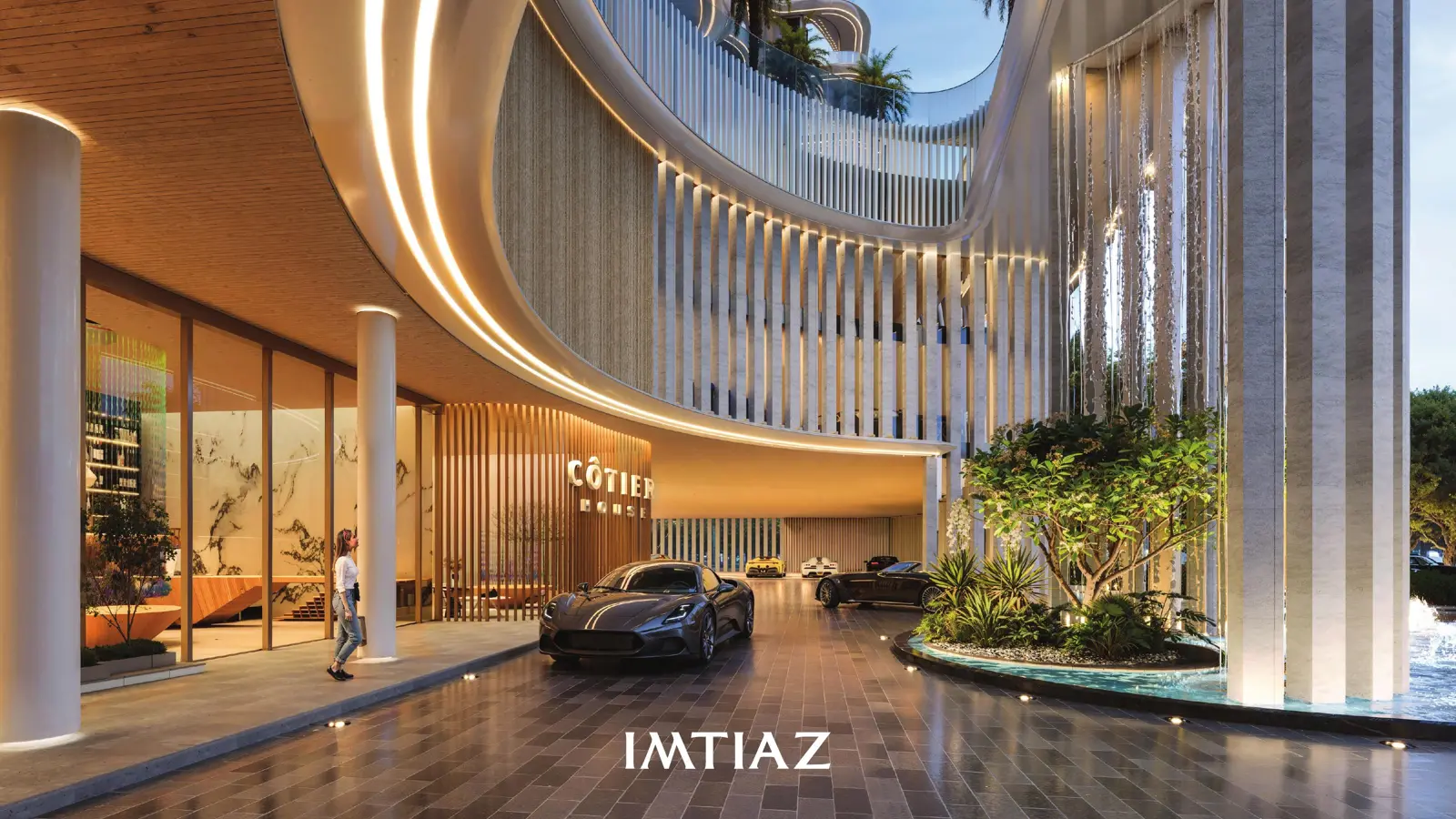 Hotel-style entrance porte-cochere with cars and water feature