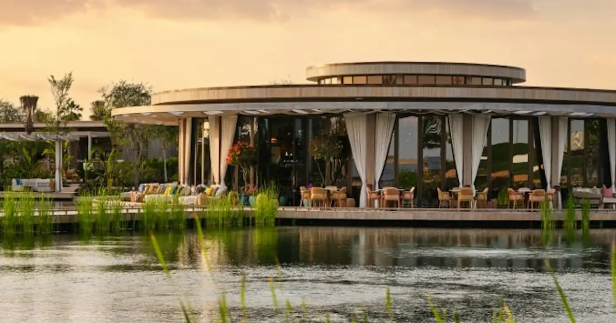 Round lakeside pavilion with outdoor seating at sunset