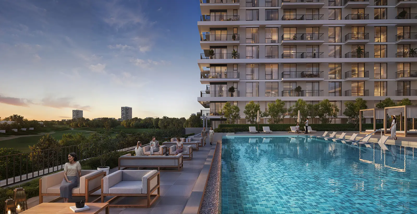 Pool deck with lounge seating beside the residential building at dusk