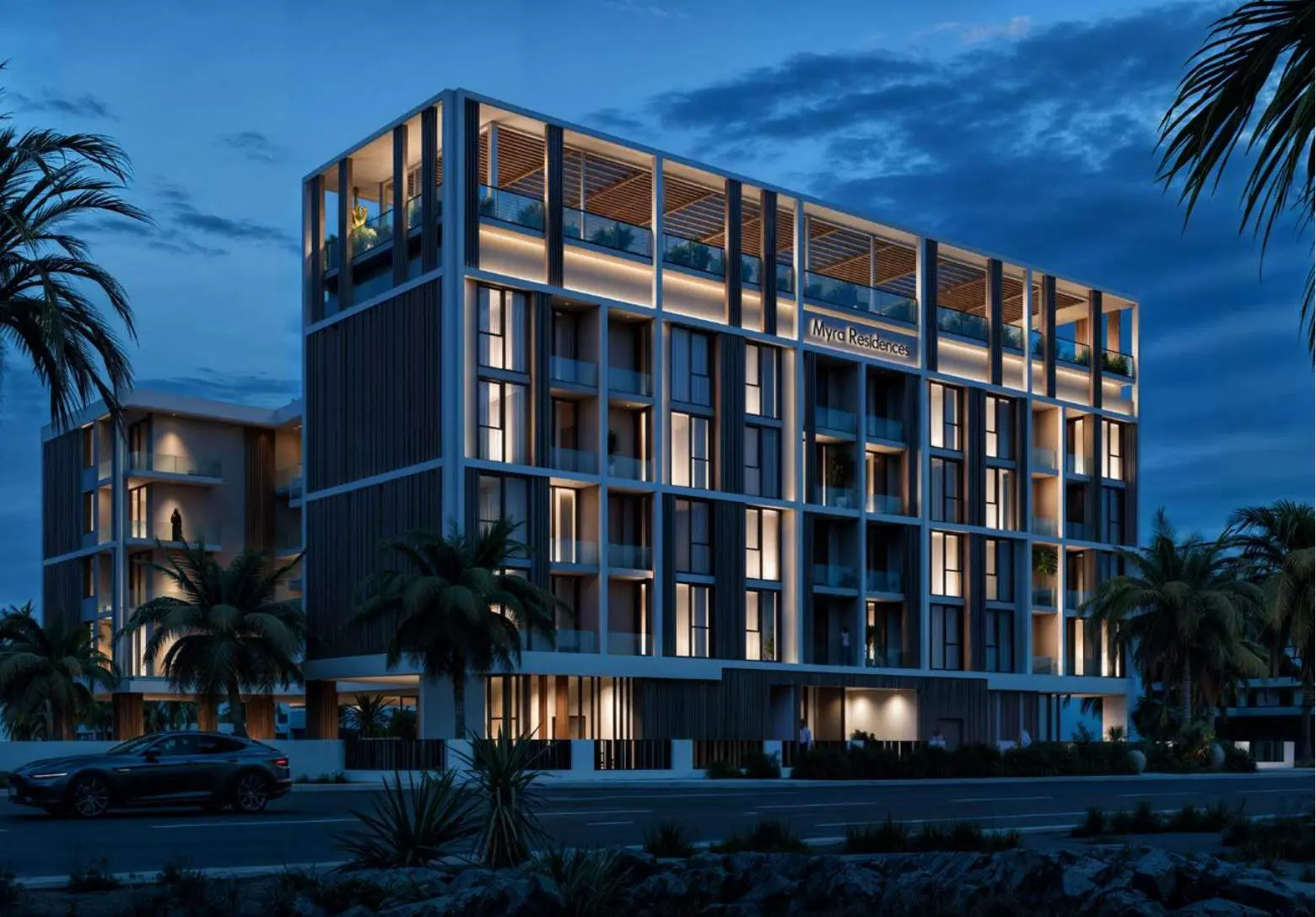 Building at dusk with lit facade and palms