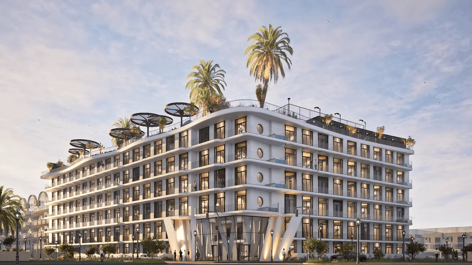 White curved building with rooftop canopies and palms