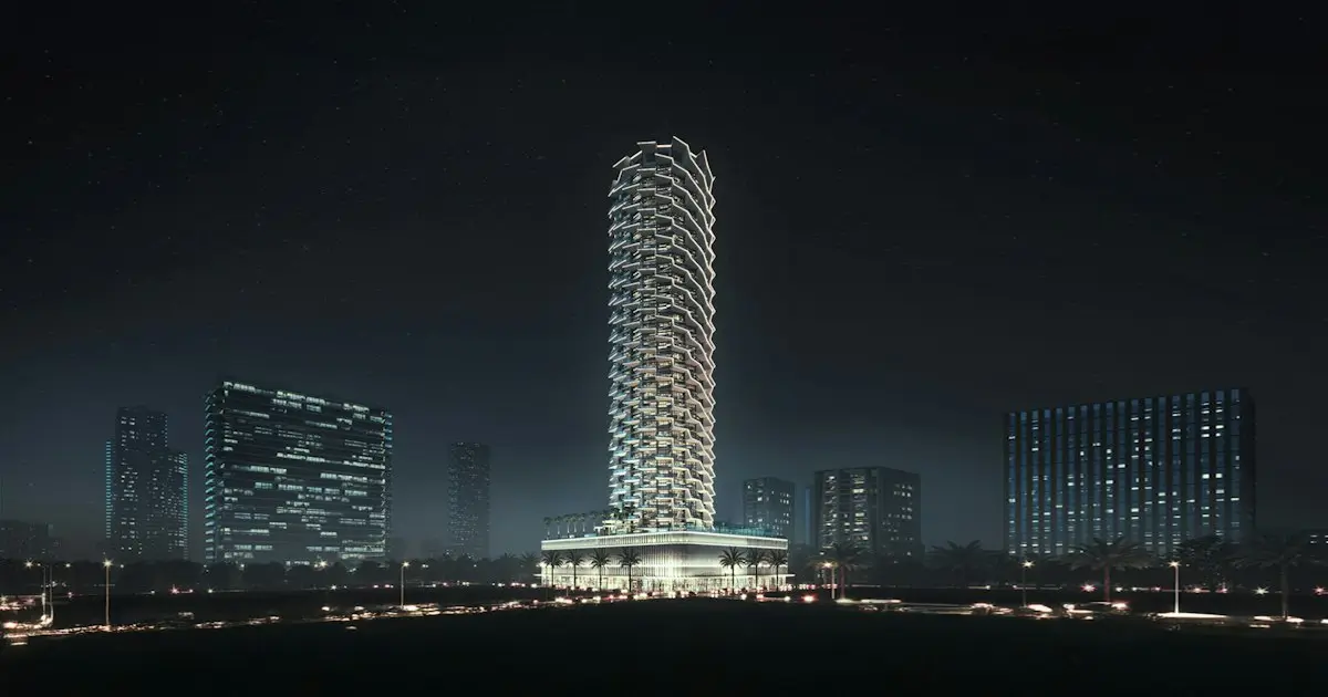 Lit tower at night among city buildings
