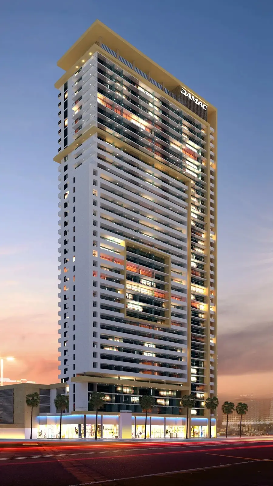 Tall tower with white balconies and DAMAC sign at dusk