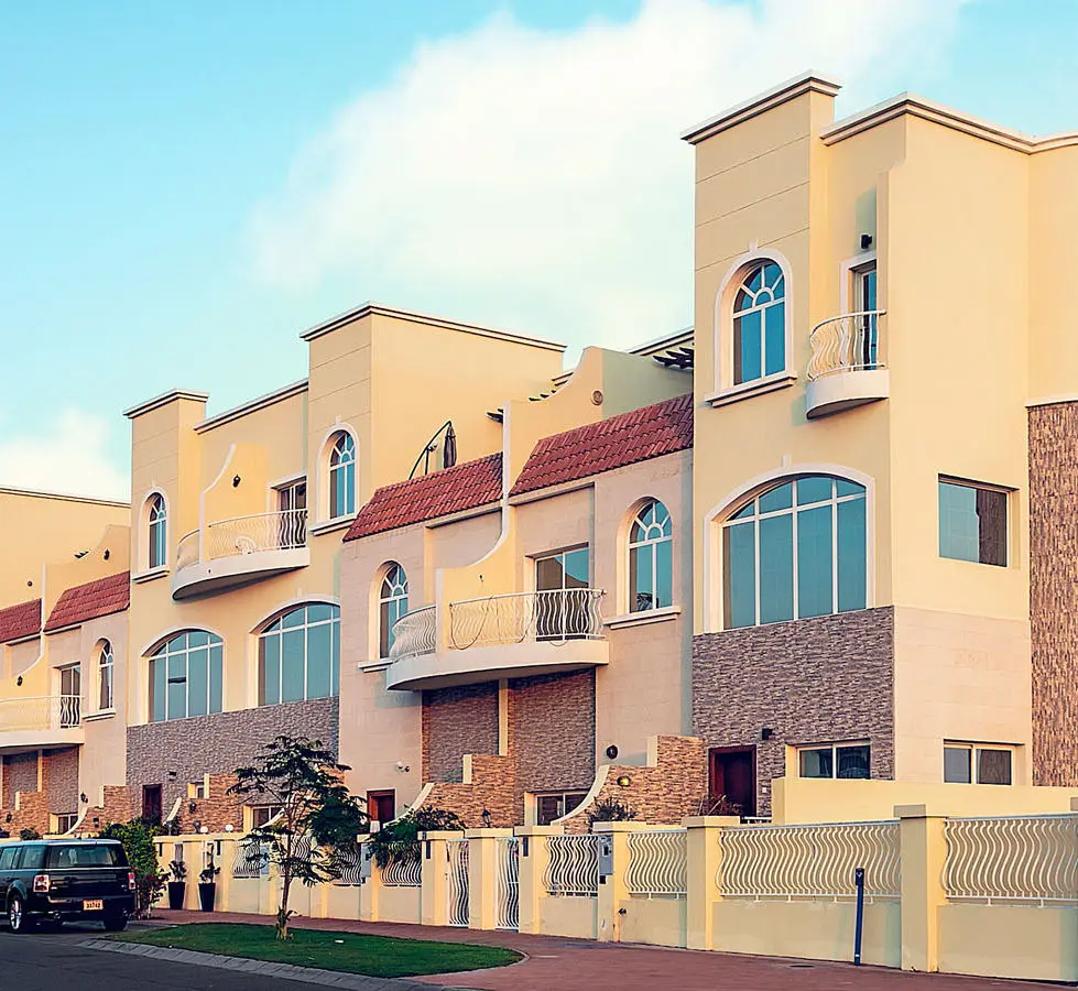 Completed townhouse row with arched windows and balconies