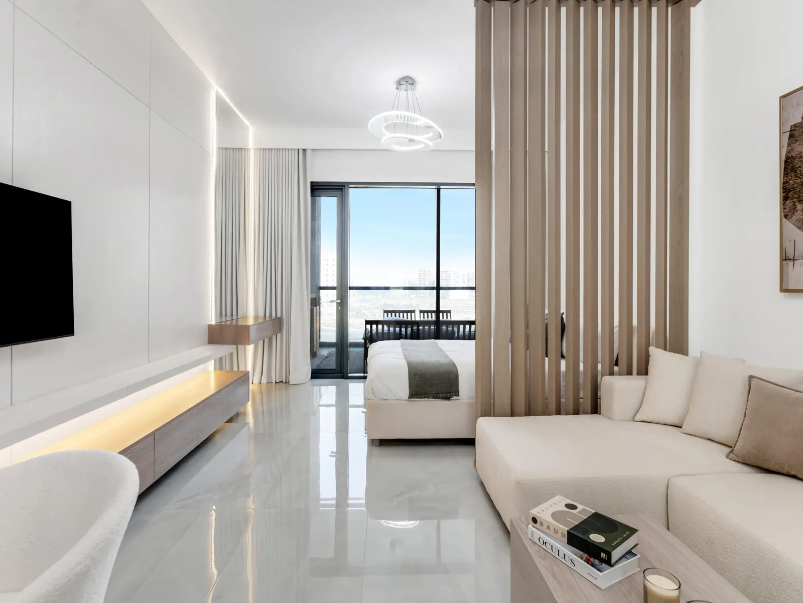 Open studio with sofa, bed and balcony view