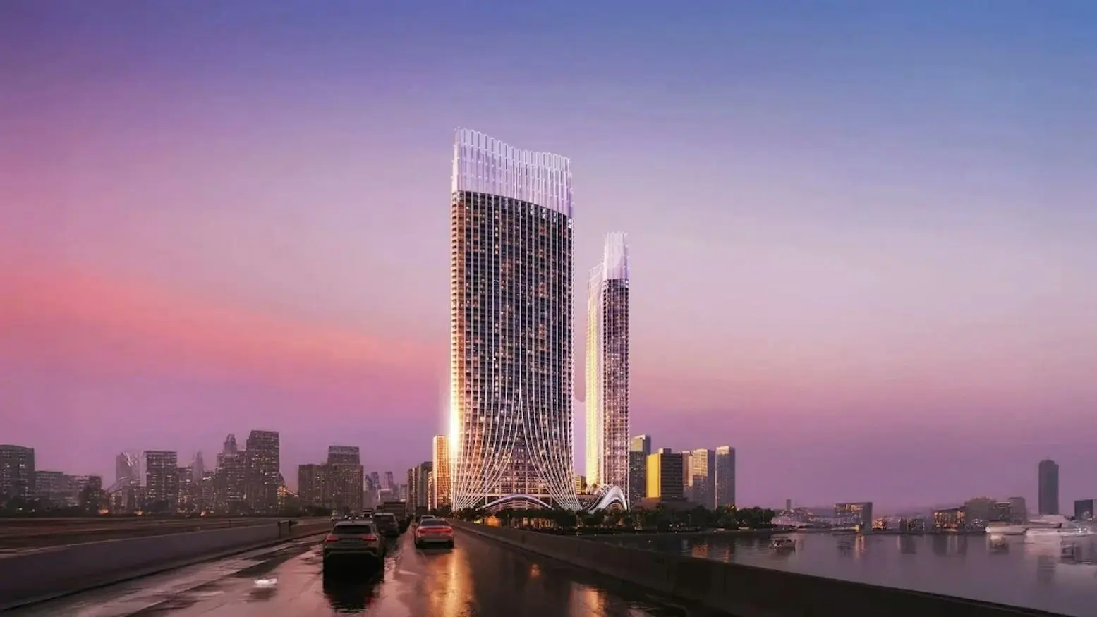 Two tall towers at dusk beside waterfront road