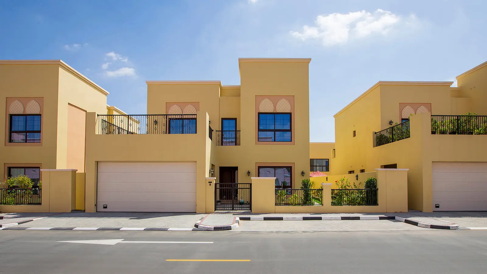 Yellow villa facades with garage doors and terraces