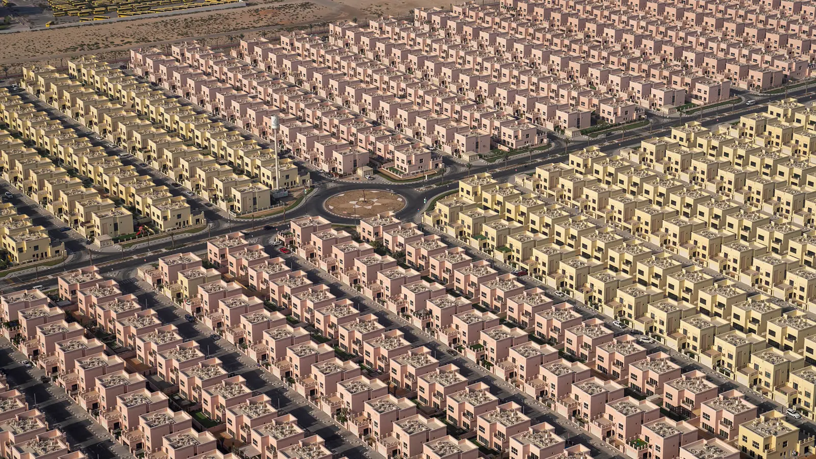 Aerial view of rows of pink and yellow villas