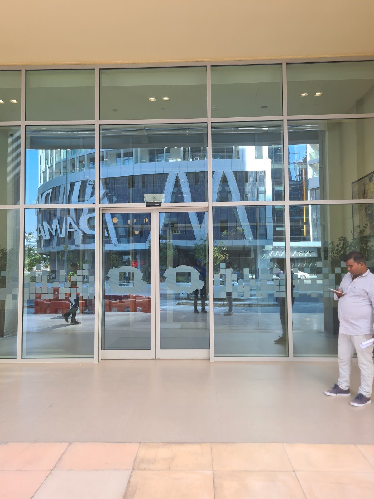 Glass entrance doors with reflections of nearby tower