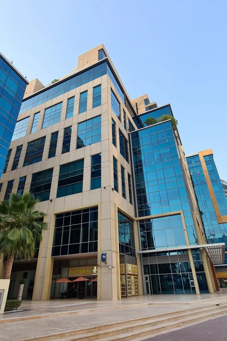 Beige stone and blue glass tower from street level