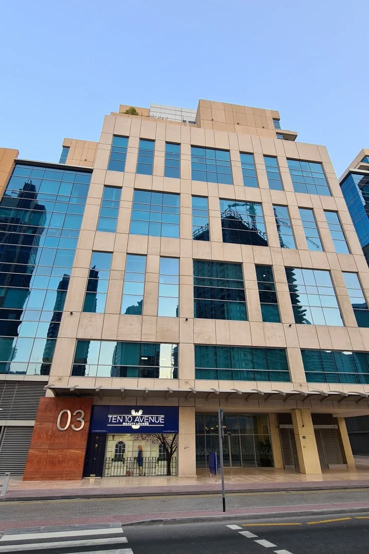 Beige stone and glass facade with '03' signage