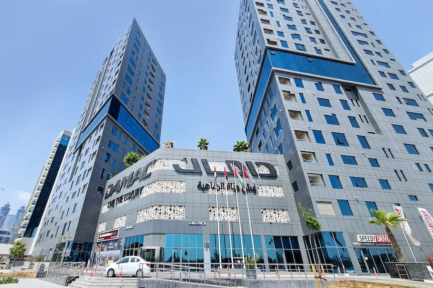 Twin towers rising above podium with Damac signage