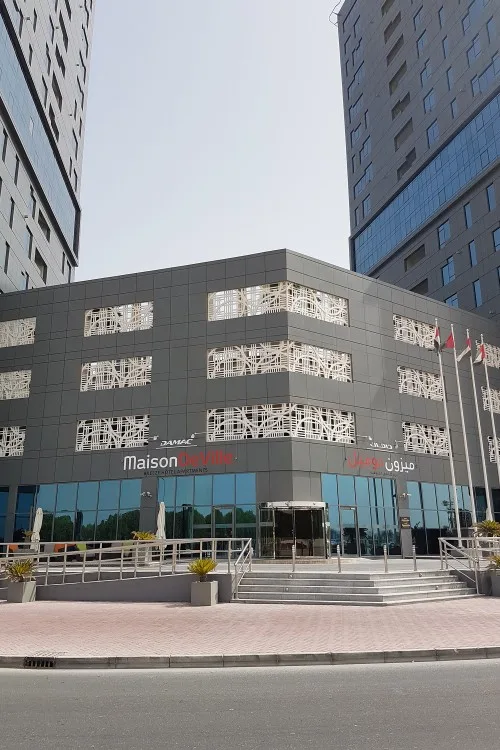 Podium entrance with patterned screens and Maison Deville sign