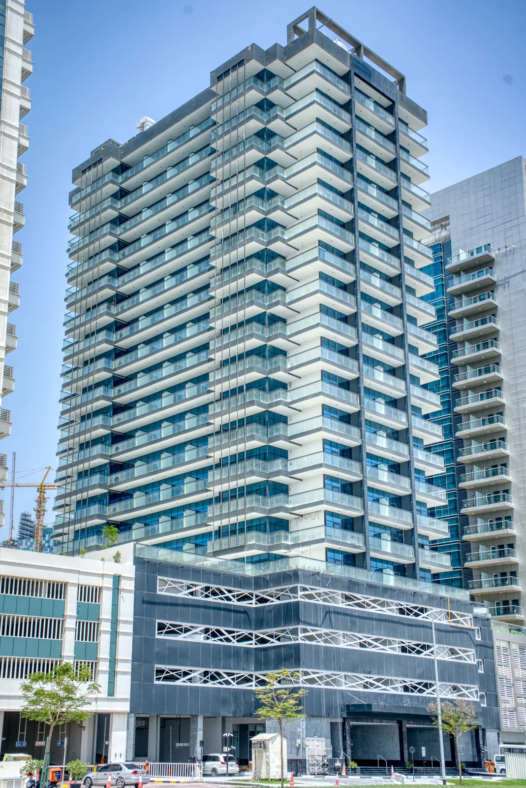 Corner view of tower with stepped balconies and podium