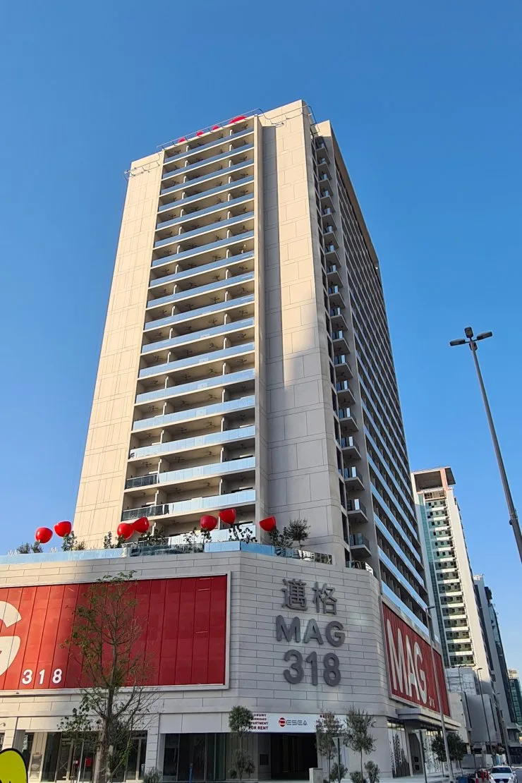 Tower seen from street level, beige facade, MAG 318 sign