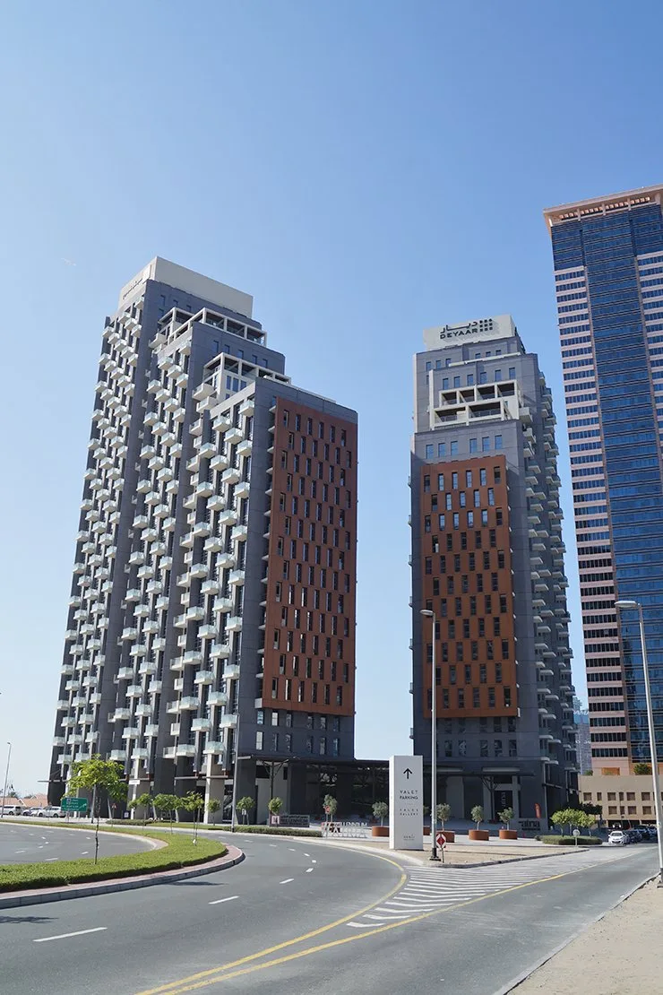 Two towers with rust-colored panels from the street