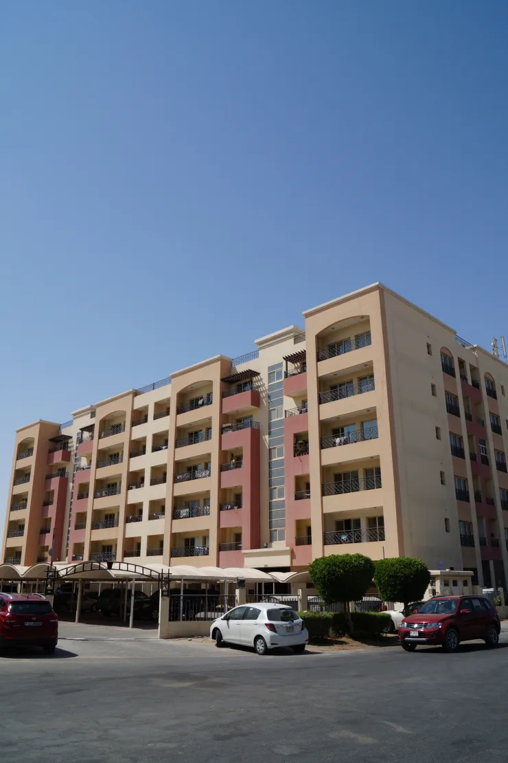 Peach and pink mid-rise apartment block with arched balconies