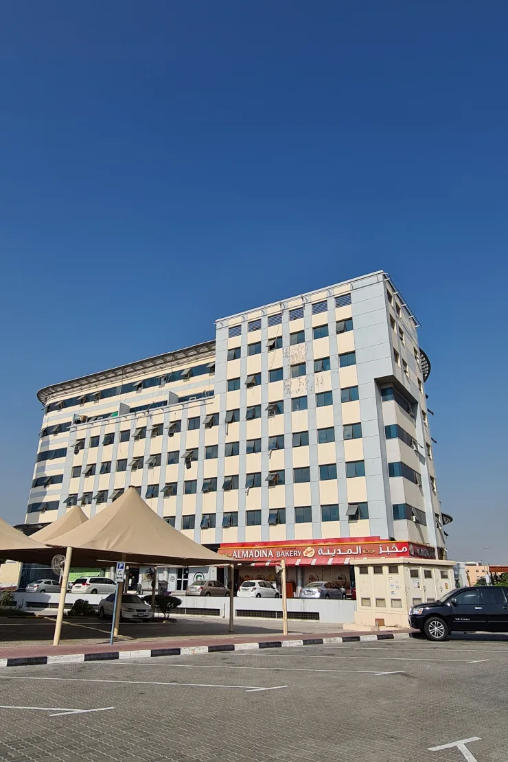 Side wing facade with Almadina Bakery at base