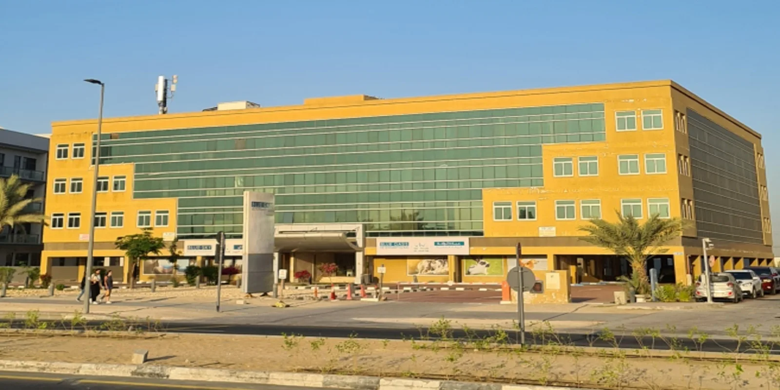 Yellow office building with green glass facade, street view
