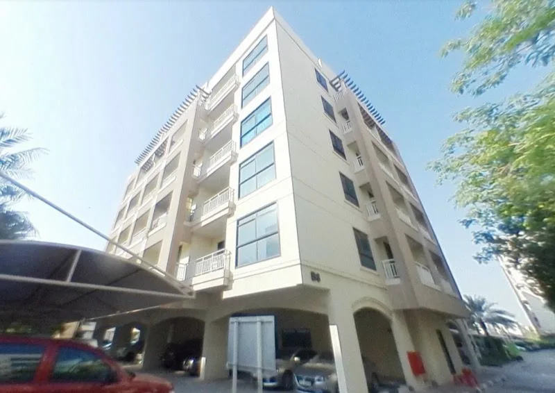 Full-height cream building, number 84 by the entrance