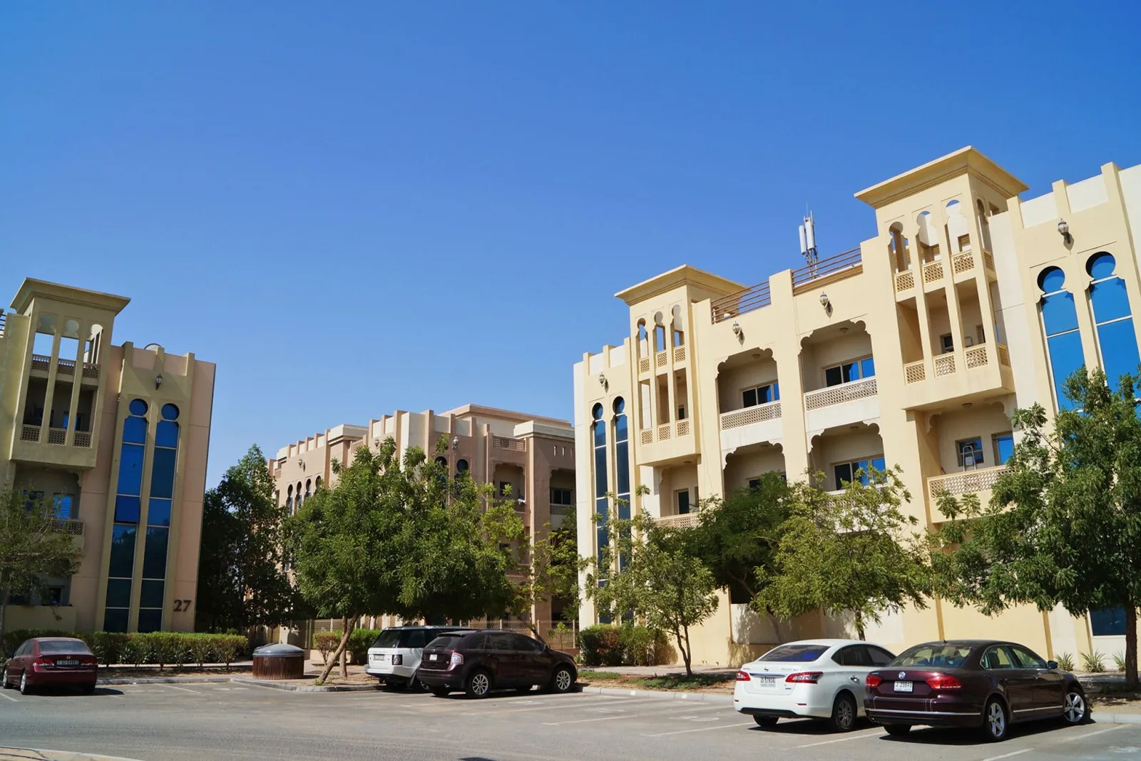 Cream low-rise block with balconies and blue windows