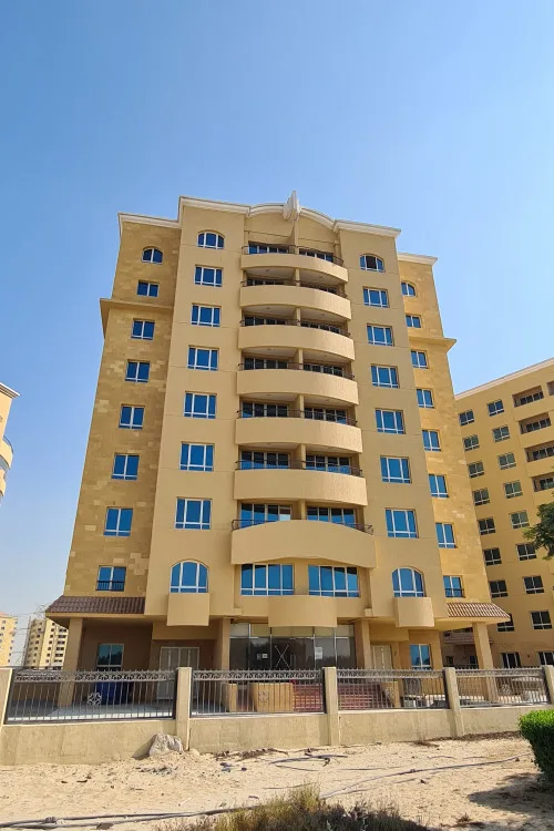 Ground-up view of curved-balcony tower with crest