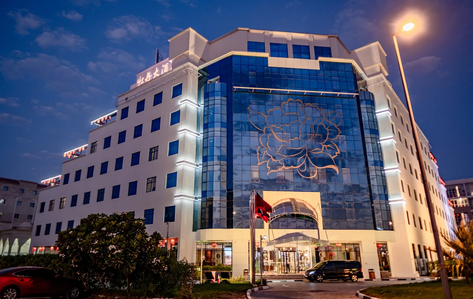 Peony Hotel facade lit up at dusk