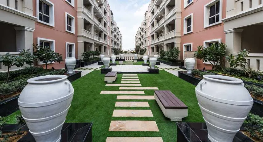Landscaped courtyard between pink and cream buildings