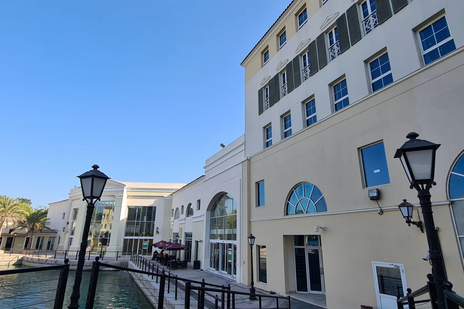 Canal-side building facade with arched glazing and lamps