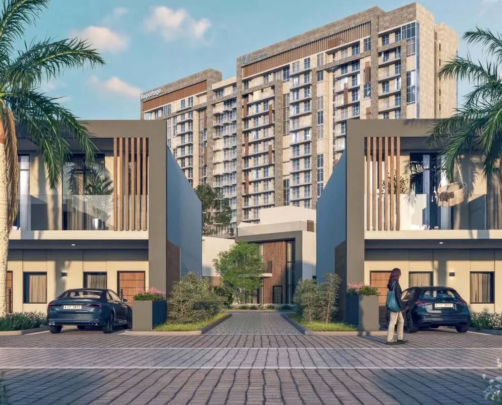 Tower rising behind townhouses, Reportage and Verdana signage