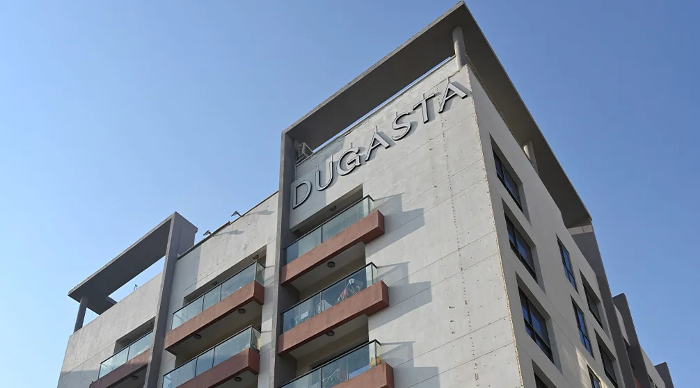 Upward view of the facade top with Dugasta sign, 1006x558