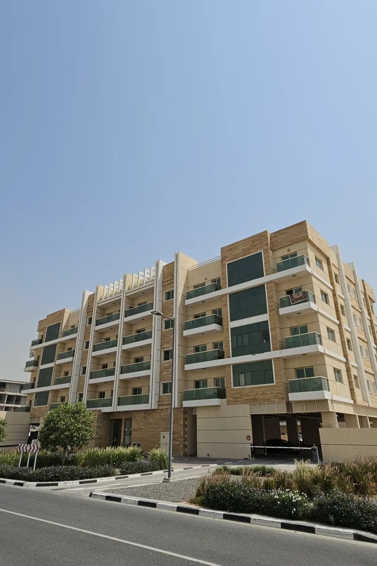 Corner view of building with green glass balconies