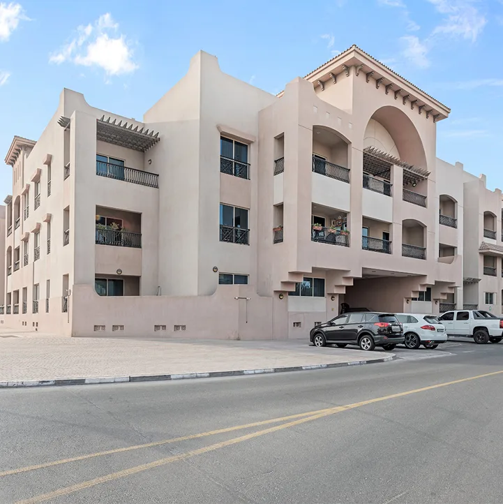 Beige low-rise with arched balconies, street view