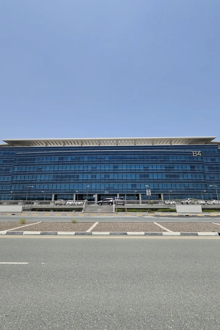 Blue glass office building labelled B4, street view