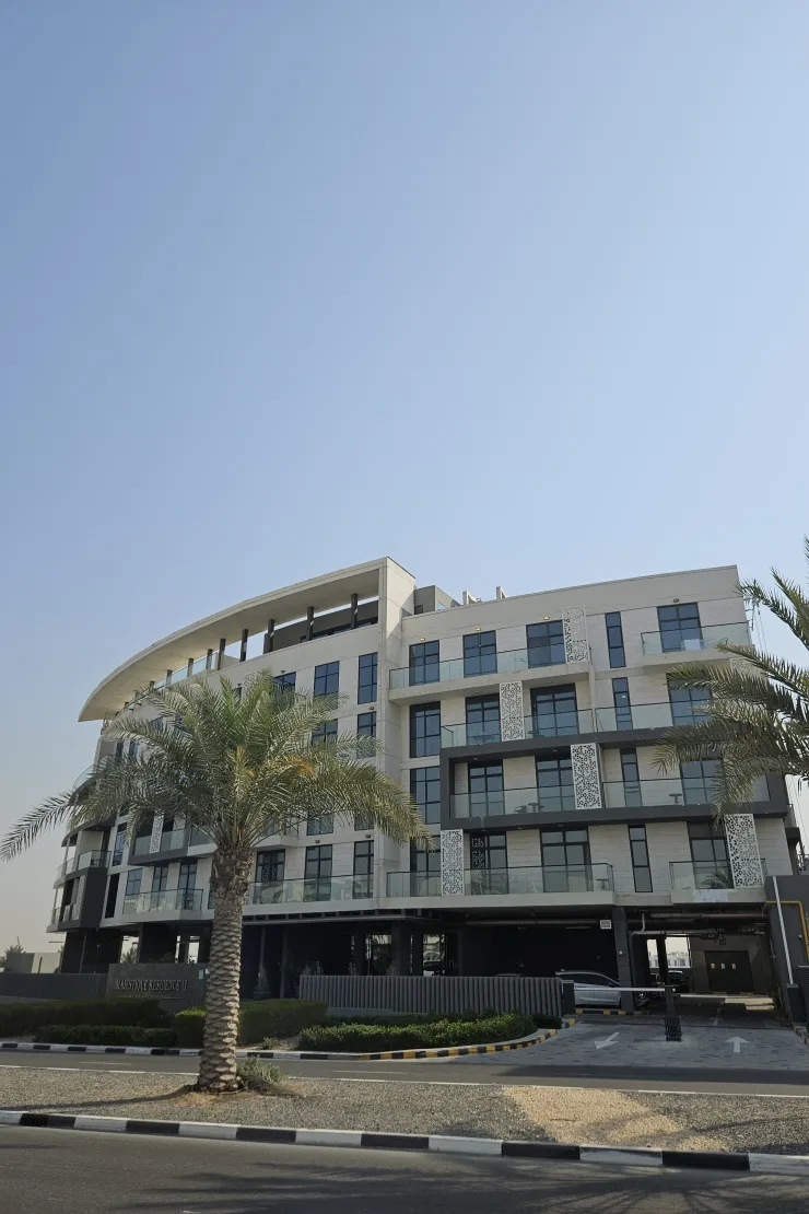 Completed building with curved roof, laser-cut screens, palm in front