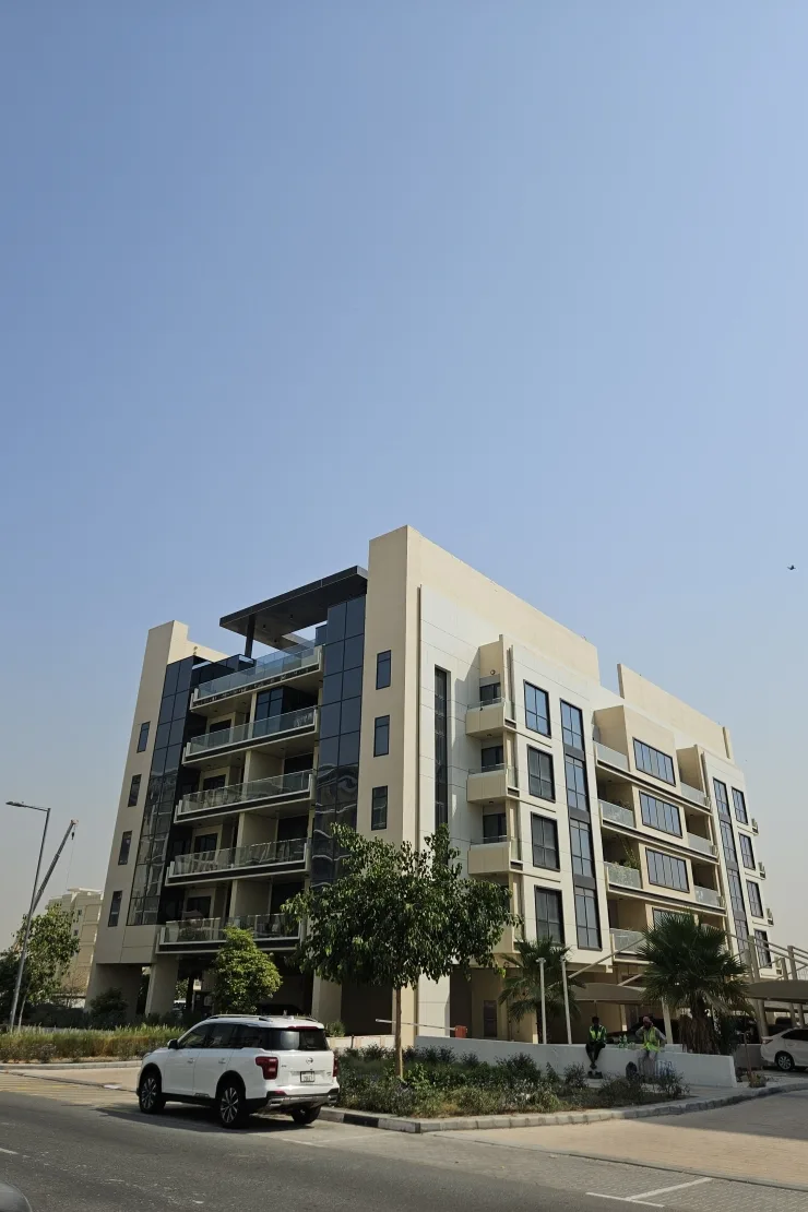 Cream six-storey residential building with balconies, street view
