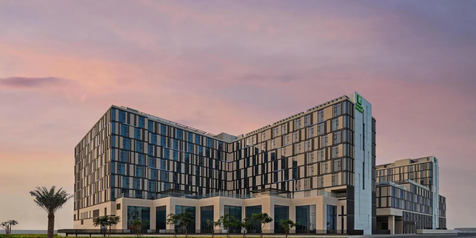 Full hotel exterior at dusk with low wing