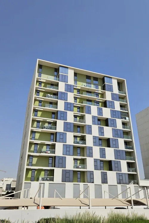 Full-height green and blue facade with balconies