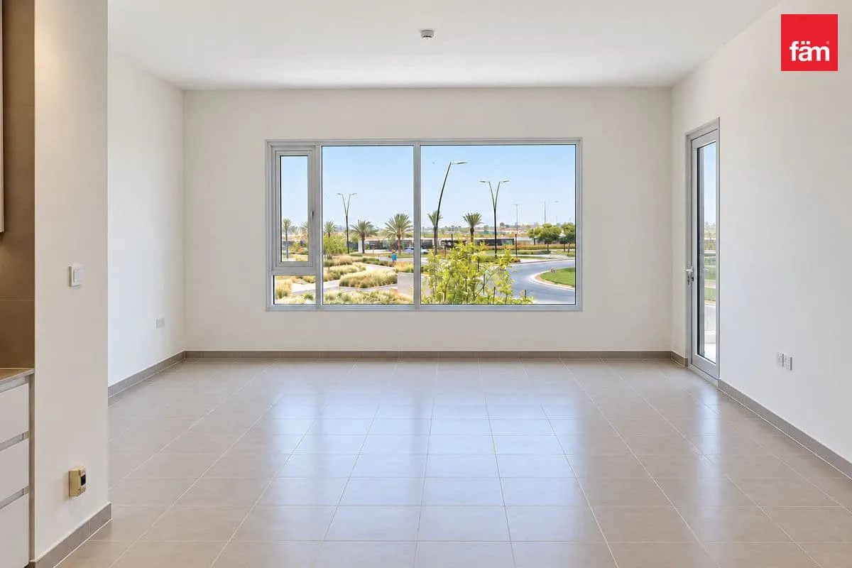 Ground-floor window view over landscaped road and palms