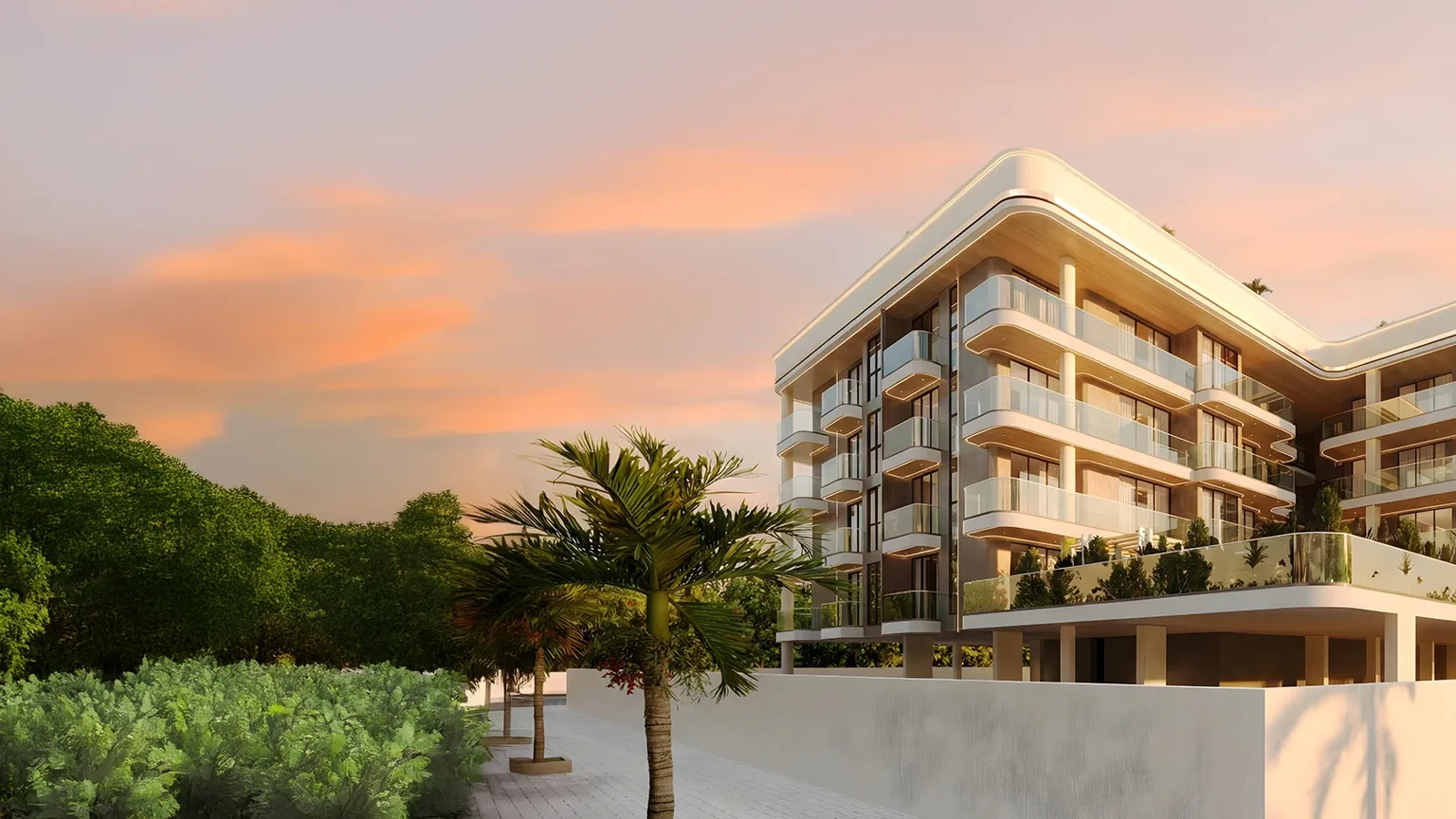 Low-rise curved cream building with glass balconies at dusk