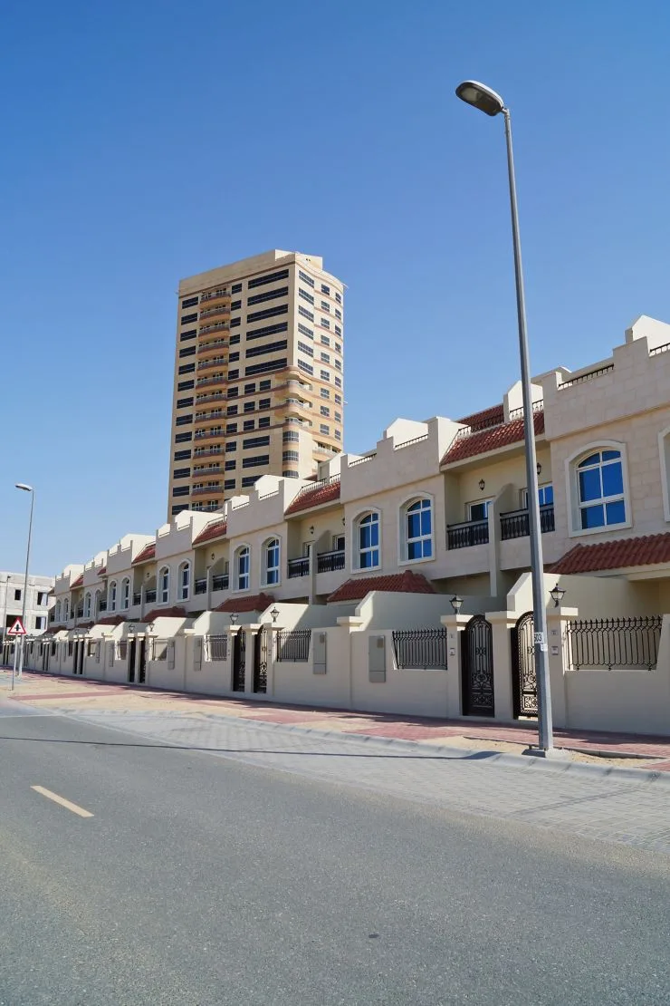 Tower behind row of townhouses, completed, clear sky