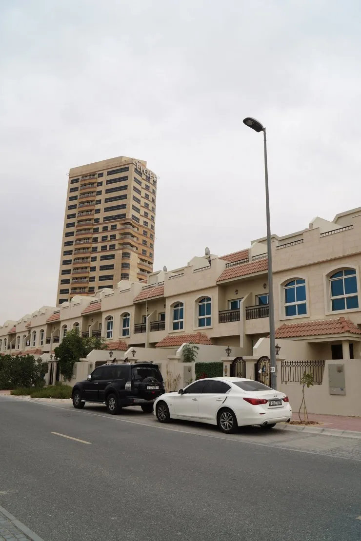 Tower and townhouse row from street, completed