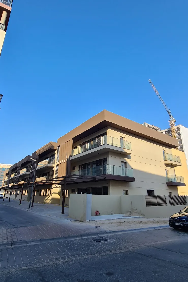 Corner block with glass balconies and brown fascia