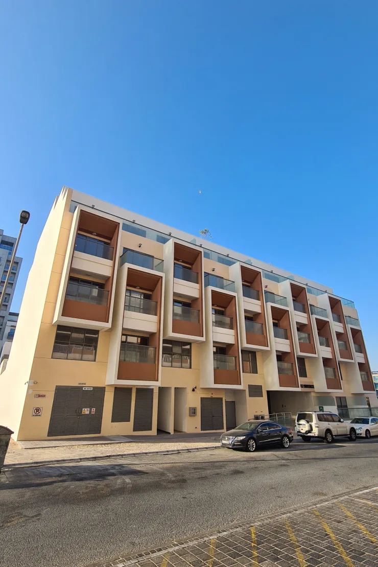 Front facade with orange recessed balconies, street view
