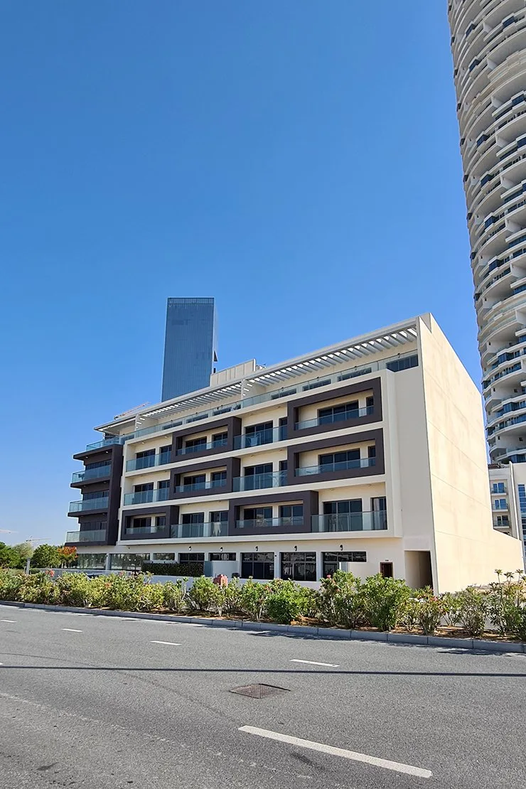 Five-storey beige building with brown balconies, street view