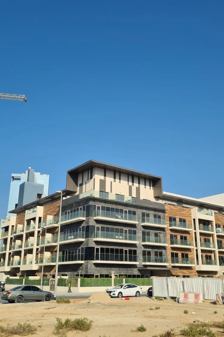 Corner view of completed building with dark stone base