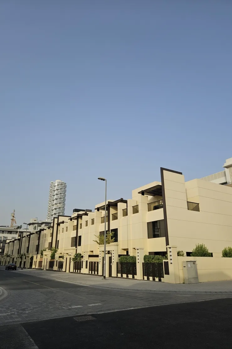 Townhouse row along street, twisted tower behind