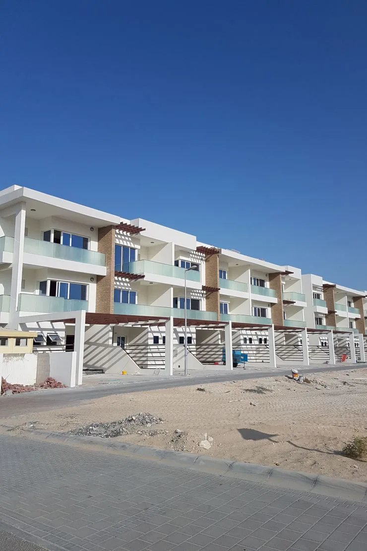 Row of townhouses with brick columns and glass balconies